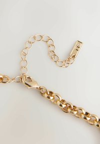 Goldene Kettenhalskette mit abwechselnd glatten und strukturierten ovalen Gliedern, mit einem Verschluss und einer kleinen Akzentperle.