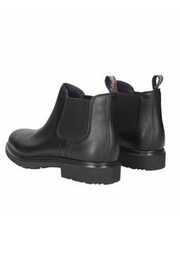 Stivaletti neri in pelle con pannelli laterali elastici, punta rotonda e suola in gomma texturizzata. Presentano linguette per un facile indossamento.