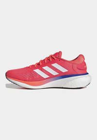 Zapatilla de running rosa con parte superior de malla ligera, diseño de tres rayas blancas, suela acolchada y un acento degradado de naranja a azul.