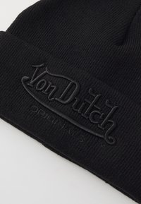 Gorro de punto negro con un logo bordado "Von Dutch" en relieve en la parte frontal, de textura suave y diseño de ajuste ceñido.