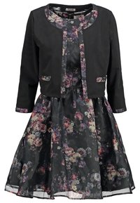 Svart kort jacka med blommig klänning som har stora blommönster i lila, rosa och vitt på en svart bakgrund, plisserad kjol.