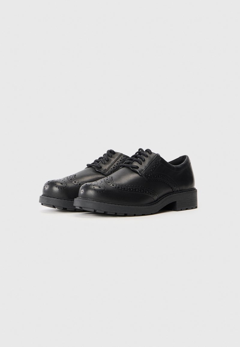 Zapatos de cuero negro tipo brogue con detalles perforados, punteras redondeadas y suelas de goma texturizadas. Diseño tradicional de cordones con tacones bajos.