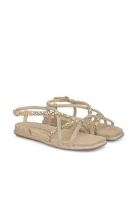 Platte sandalen met een beige nep-suède materiaal, een strappy ontwerp met metalen accenten, versierd met rhinestones en een enkelbandje.