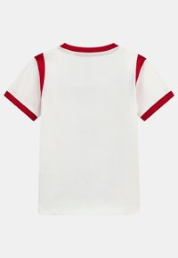 T-shirt bianco a maniche corte con dettagli rossi sulle maniche e sul colletto, realizzato in morbido cotone. Nessun motivo grafico visibile.