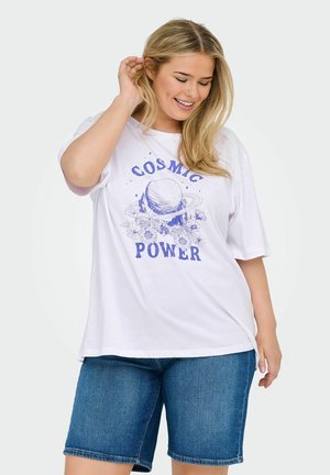 T-shirt en coton blanc avec un imprimé graphique bleu représentant des planètes et des fleurs. Coupe décontractée avec des manches courtes, associé à un short en denim.