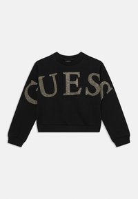 Black cropped sweatshirt with long sleeves, featuring large gold studded "GUESS" lettering across the front. Soft texture and ribbed cuffs.