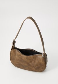 Sac à main en cuir marron avec un design courbé, fermeture éclair et une seule bandoulière. La surface a une finition texturée avec des coutures visibles.