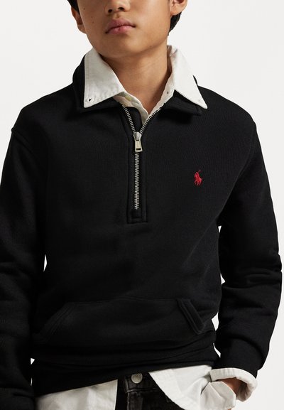 Pullover nero a metà zip realizzato in tessuto texturizzato con tasca a marsupio. Presenta una camicia colletto bianco con bottoni sotto e un logo rosso.