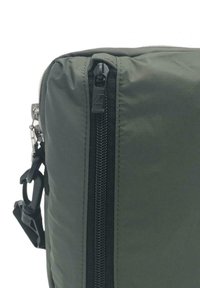 Angolo di borsa in nylon verde oliva con una cerniera nera, dotata di una fibbia in metallo argentato e tessuto testurizzato. Lieve lucentezza e design imbottito.
