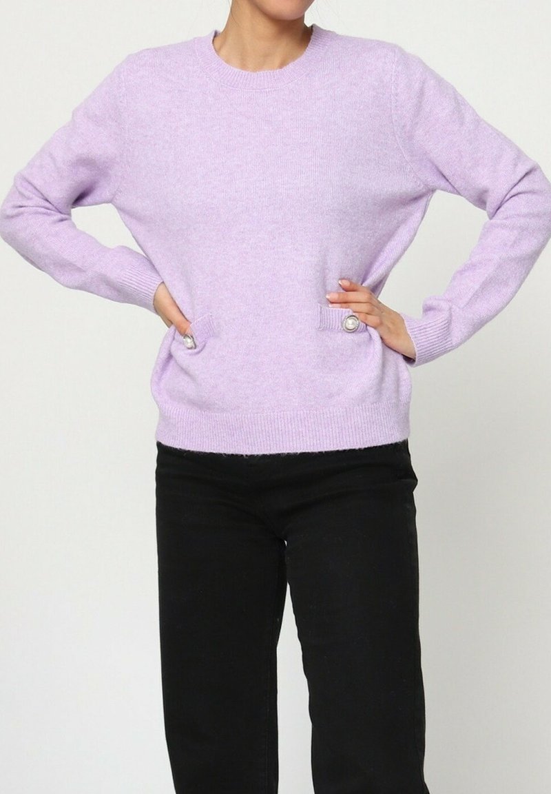 Pull en tricot lavande à manches longues, col rond, et deux poches latérales avec détails de boutons. Texture douce, coupe décontractée.