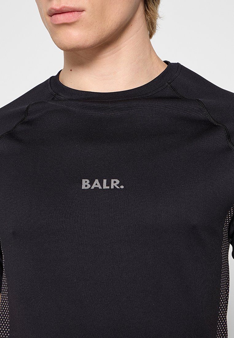 Schwarzes Sportshirt mit tailliertem Design, kurzen Ärmeln und reflektierendem "BALR."-Logo auf der Brust. Strukturierter Stoff mit gemusterten Akzenten an den Seiten.
