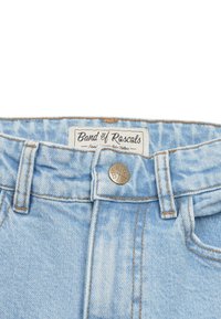 Vaaleansiniset farkut suoran leikkauksen kanssa, joissa on tehostevärinä oranssi ommel ja metallinen nappi, joka esittelee brändin "Band of Rascals."