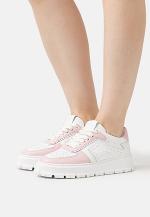 White and pink perforated leather sneakers with a chunky white sole and contrasting accents. Features lace-up design and logo detail on the tongue.