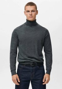 Pulover negru cu guler înalt, confecționat dintr-un material moale, având mâneci lungi și un design ajustat, purtat cu blugi închiși la culoare și o curea împletită.