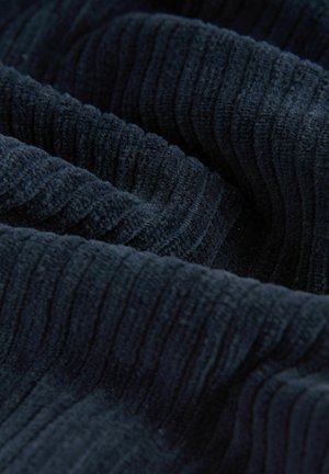 Tessuto di un blu scuro con texture che mostra motivi verticali a righe, con un aspetto morbido e peloso e una superficie leggermente fuzzy.