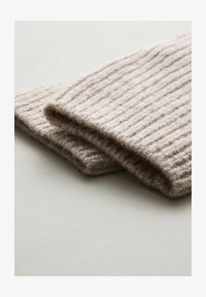 Rippiger beiger Wollstoff, gefaltet und mit weicher Textur sowie warmer Optik, ideal für Winteraccessoires.