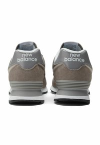 Harmaat mokkasneakerit ja verkkokangas, joissa on valkoinen välipohja. Varustettu "new balance" -brändillä valkoisena kannassa. Musta kumipohja.