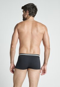 Svarta boxershorts med randig midja, som har en snug passform och slät textur, visade från bakvyn.