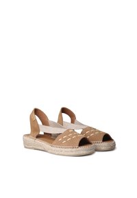 Sandali espadrilles in suede marrone con punta aperta e cinturini elastici. Presentano dettagli intagliati e suole intermedie in juta intrecciata.