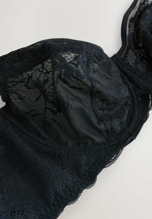 Sort blonder-bh med blomsterdekorationer, halvtransparent stof og bølgede kanter, med strukturerede skåle og justerbare stropper.