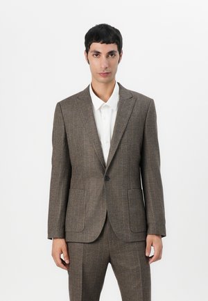 Brown plaid suit jacket with a tailored fit, notched lapels, two front pockets, and a single button closure. Worn over a white shirt.