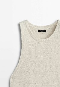 Débardeur en tricot beige clair avec un col rond, un tissu texturé et sans manches. L'étiquette indique "Massimo Dutti".