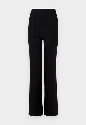 Melnas ribotas bikses ar platu kāju dizainu, elastīgu jostu un teksturētu audumu, ar vertikālām svītrām visā virsmā.