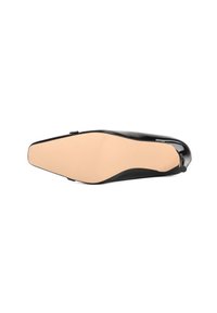 Scarpa in vernice nera con punta affusolata e superficie liscia e lucida. La suola è beige con una texture a righe, dotata di un tacco basso.