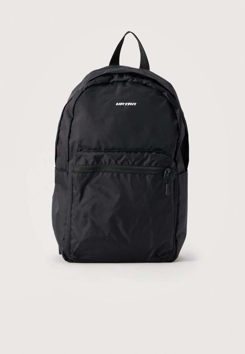 Μαύρο υφασμάτινο σακίδιο με μπροστινή τσέπη με φερμουάρ, πάνω λαβή, επενδεδυμένους ιμάντες ώμου και μικρό λευκό λογότυπο μάρκας στο πάνω μπροστινό πάνελ.