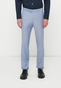 Šviesiai mėlynos kelnės su tekstūruotu paviršiumi, tiesios kojos dizainu ir pritaikyta juosta, derinamos su juodais batais.