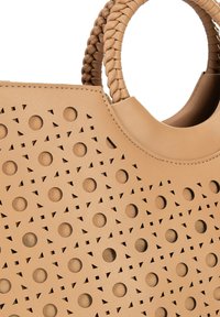 Sac à main en cuir beige avec un design perforé à cercles et triangles. Des poignées tressées et une texture lisse viennent compléter le style.