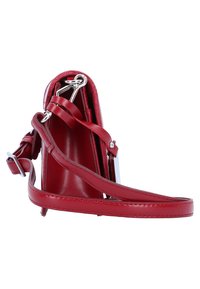Rote Lederhandtasche mit strukturiertem Design, verstellbarem Trageriemen und silbernen Beschlägen. Glatte Textur und minimalistisches Interieur sichtbar.
