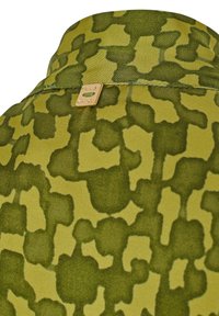 Camicia a maniche corte con motivo camouflage, caratterizzata da diverse sfumature di verde e una texture morbida. Dettaglio in metallo dorato al colletto.
