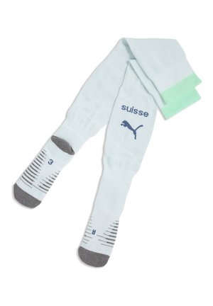Calcetines deportivos blancos con punteras grises, puños verdes, logo de Puma y texto "suisse", con patrones a rayas negras y azules y marcas de talla.