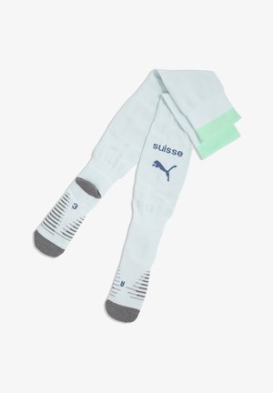 Calcetines deportivos blancos con punteras grises, puños verdes, logo de Puma y texto "suisse", con patrones a rayas negras y azules y marcas de talla.