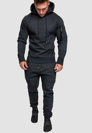 Dunkelgraues Hoodie- und Jogginganzug-Set aus weichem Material, mit einer Reißverschlusstasche am Ärmel und verstellbaren Kordelzugdetails.