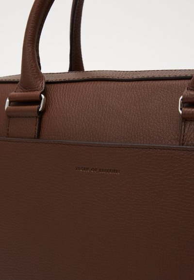 Sac en cuir marron avec une surface texturée, des poignées robustes et des accessoires en métal argenté. Logo en relief sur le bas à l'avant.