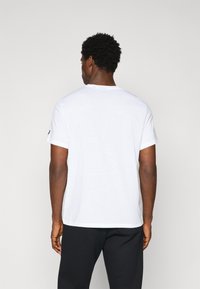 Hvid bomulds T-shirt med korte ærmer, rund halsudskæring og lige kant. Ingen synlige mønstre eller udsmykninger.