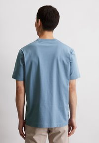 Korte mouwen blauwe katoenen t-shirt met een ronde hals, ontspannen pasvorm, eenvoudig ontwerp en gladde textuur. Geen zichtbare patronen of graphics.
