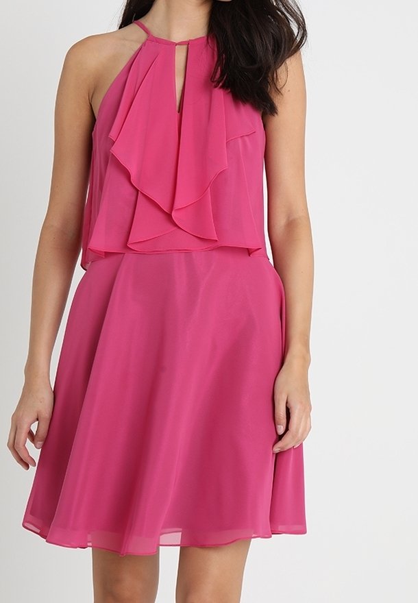 Fuchsia halterneck-klänning med lager av volanger på bodice, nyckelhål-detalj och en utsvängd kjol, tillverkad av lätt och mjukt tyg.