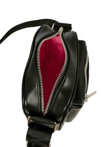 Borsa a tracolla in pelle nera con cerniere argentate, aperta per rivelare un vivace rivestimento interno rosa e una tracolla nera regolabile.