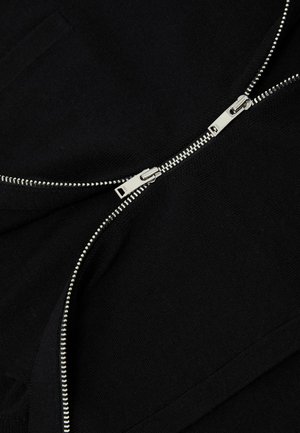 Čierny sveter na zips s kovovým zipsom, hladkou textúrou a minimalistickým dizajnom s ukrytým detailom vrecka.