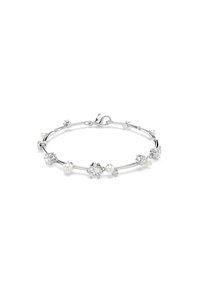 Srebrna narukvica z tanke, ukrivljene oblike, okrašena različitim prozirnim kamenjem i okruglim biserima, koja prikazuje mešavinu tekstura i oblika.