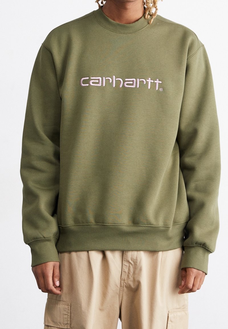 Oliivinvihreä collegepaita, jossa on resorit hihansuissa ja helmassa, päällä vaaleanpunainen kirjailtu "carhartt"-logo. Valmistettu pehmeästä, teksturoidusta materiaalista.