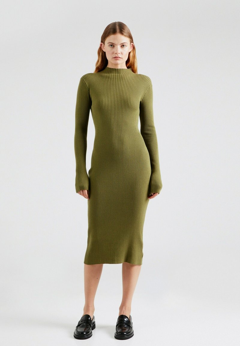 Rippiges, langärmliges Kleid aus olivgrünem Stoff, figurbetonte Silhouette, Rundhalsausschnitt, mit Midi-Länge und Schlitz am Saum.