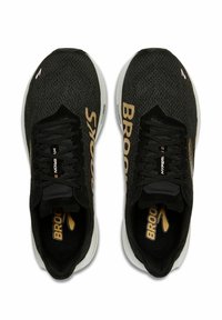 Zapatillas deportivas negras con parte superior de malla de punto, con el logotipo dorado de "Brooks" y una suela blanca acolchada. Diseño con cordones y cuellos acolchados.
