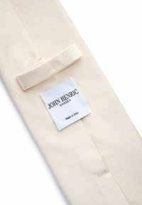 Lichtbeige overhemdd met een subtiele visgraatpatroon. Heeft een opstaande kraag en een wit label met de tekst "John Henric, Zweden, Gemaakt in Italië."