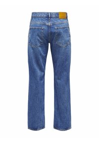 Jeans de mezclilla azul con corte recto, cinco bolsillos y una etiqueta de cuero marrón en la parte trasera de la cinturilla. Tejido texturizado con áreas desgastadas.