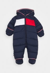 Donkerblauwe gewatteerde sneeuwoverall met een wit en rode borstpaneel, capuchon, volle rits en elastische manchetten met een rood en witte streepdetail.