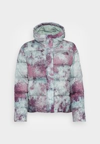 Doudoune avec capuche, présentant un motif moucheté violet et bleu clair et le logo The North Face sur la poitrine.